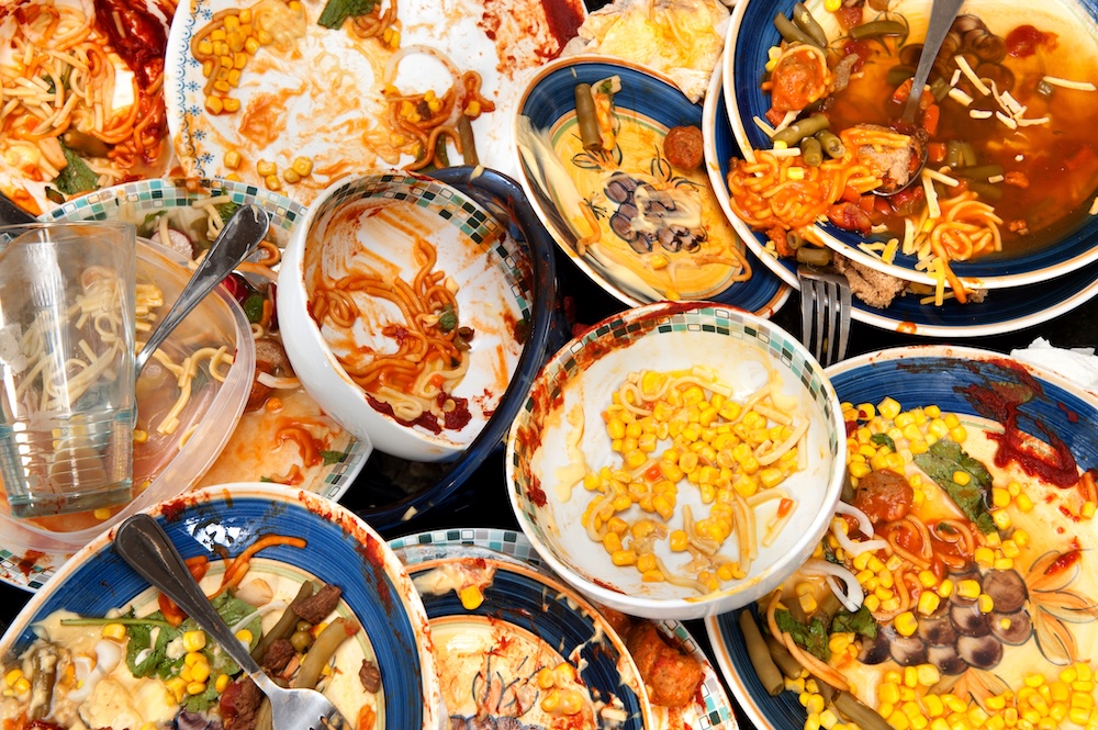 dirty dishes with half eaten food wasted