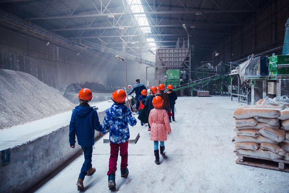 People touring a factory with concrete