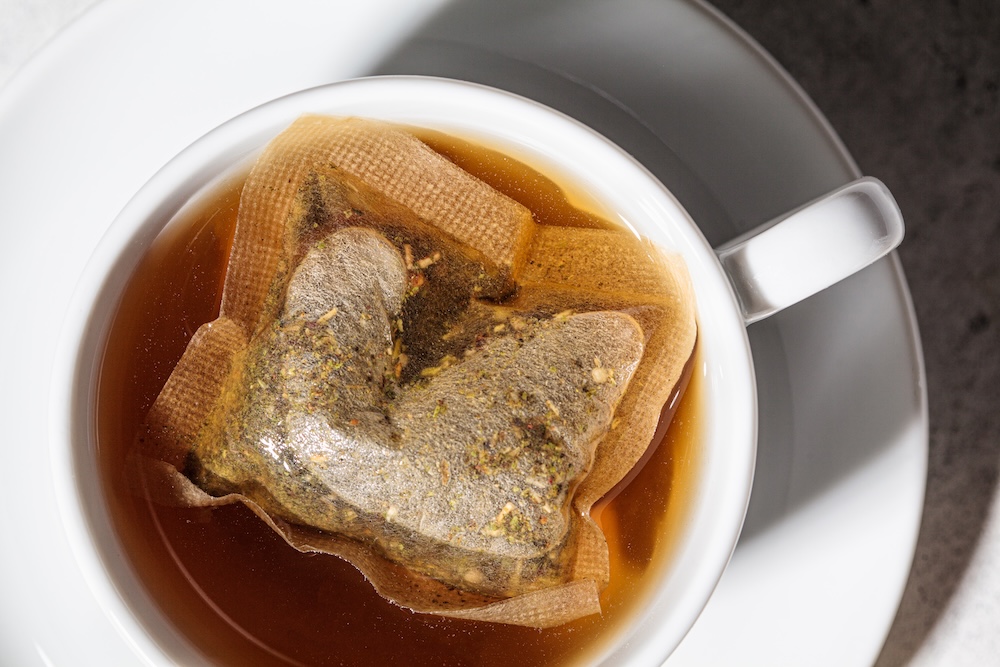 herbal tea bag floating in a hot cut of water