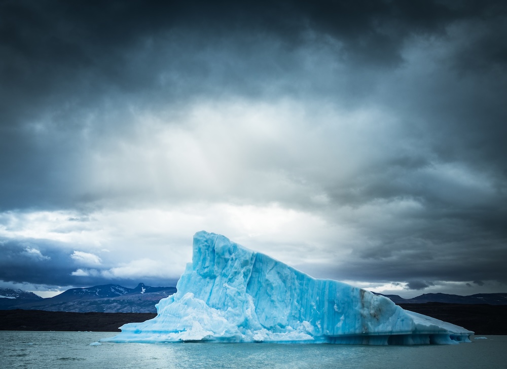 iceberg against overcast sky slowly melting