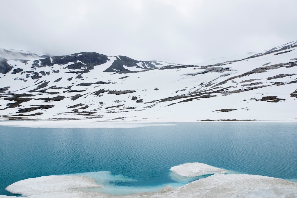 glacial lake with snow and ice and blue water