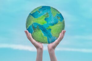 protecting the earth with hands holding it up high