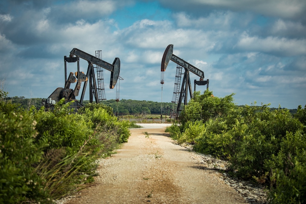 two oil pump jacks against a blue sky