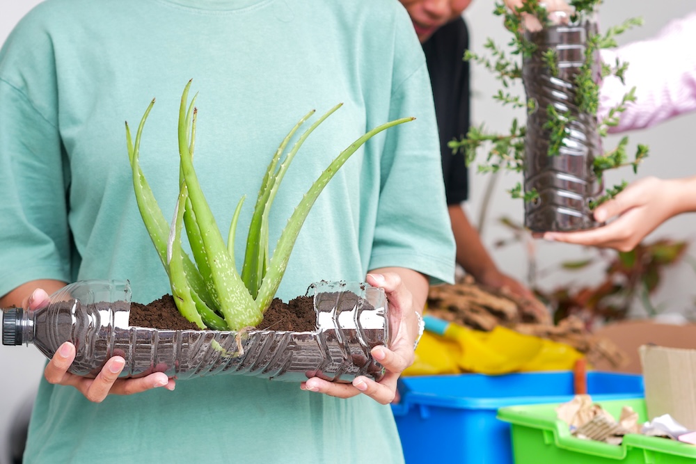 young person holding a planter made out of recycled bottle