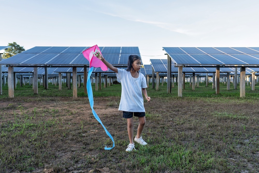 Solar panel on a solar farm with a young girl playing