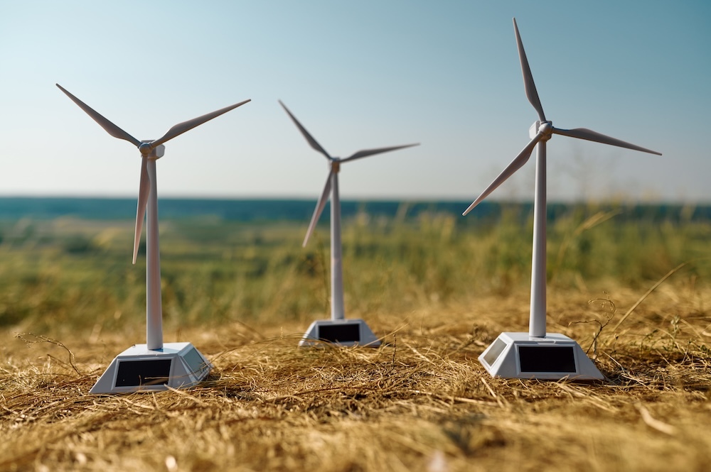 Three wind turbines on the ground against a blue sky