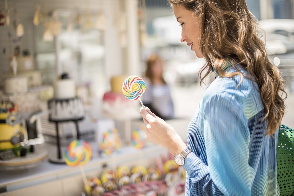 Woman holding a piece of candy browsing