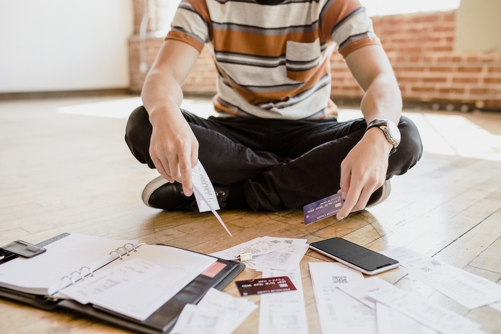 Young person paying bills on the floor