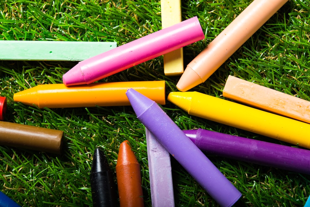 Crayons on grass without labels