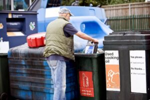 A man recycling oil in correct bins