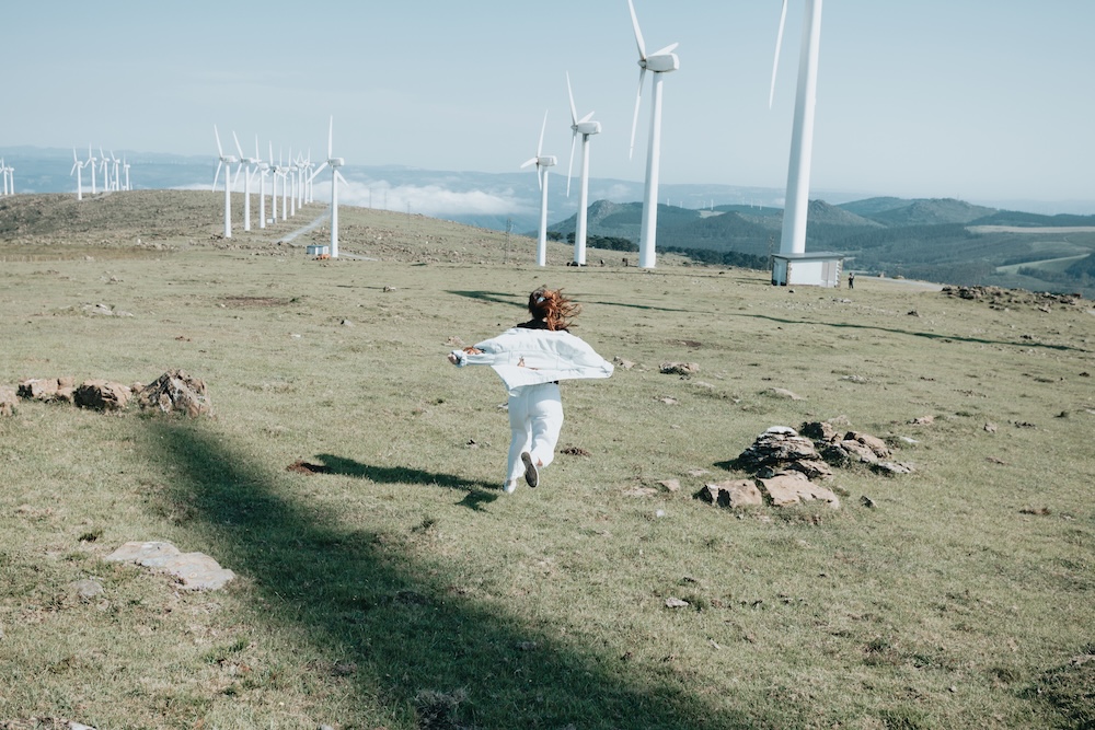 Girl running to wind turbines