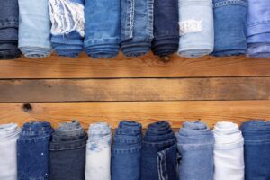 Different blue jeans on a wooden table