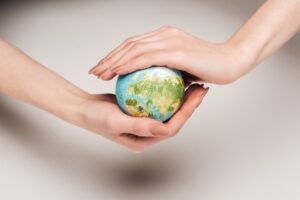 Person holding earth between their hands protecting it