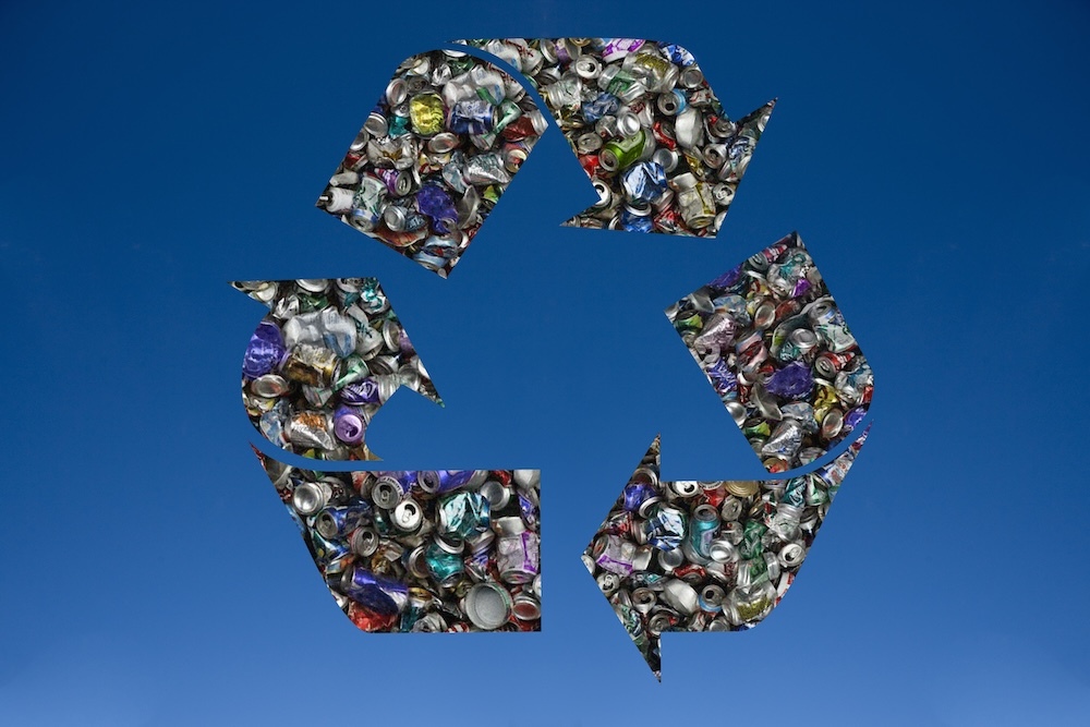 Recycled tin cans in shape of recycling symbol