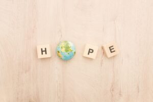 Wooden cubes spelling the word hope, with the o being an earth globe