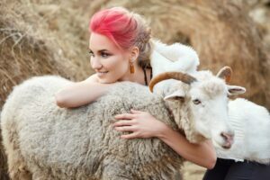 Young stylish woman hugging a ram