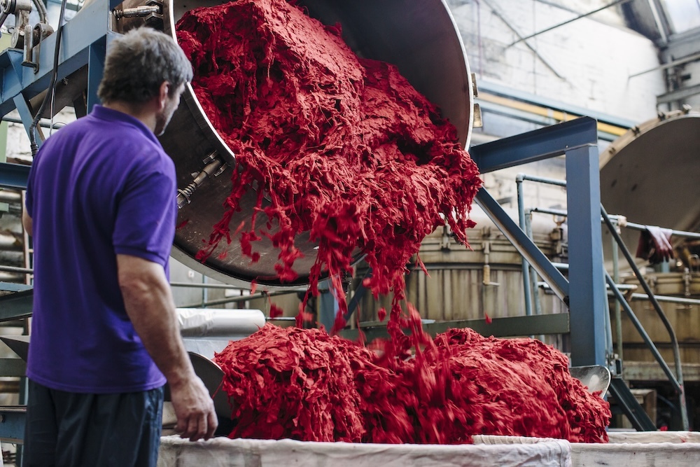 Textile factory worker processing dyed material