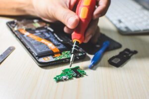 person using tools to repair a smartphone