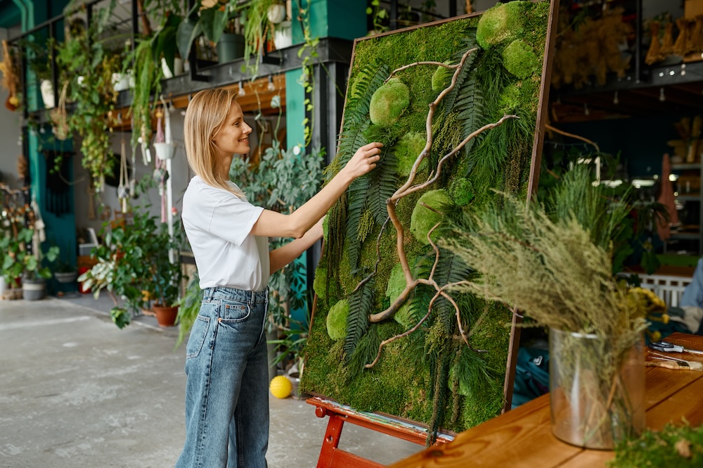 young woman creating plant art with moss