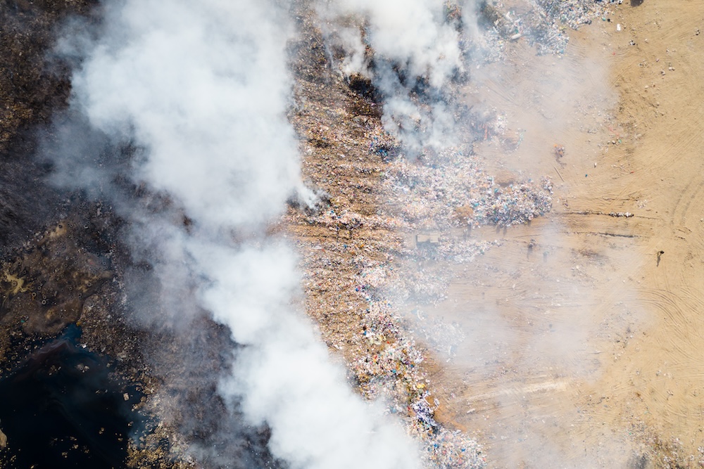 aerial view of landfill with burning trash
