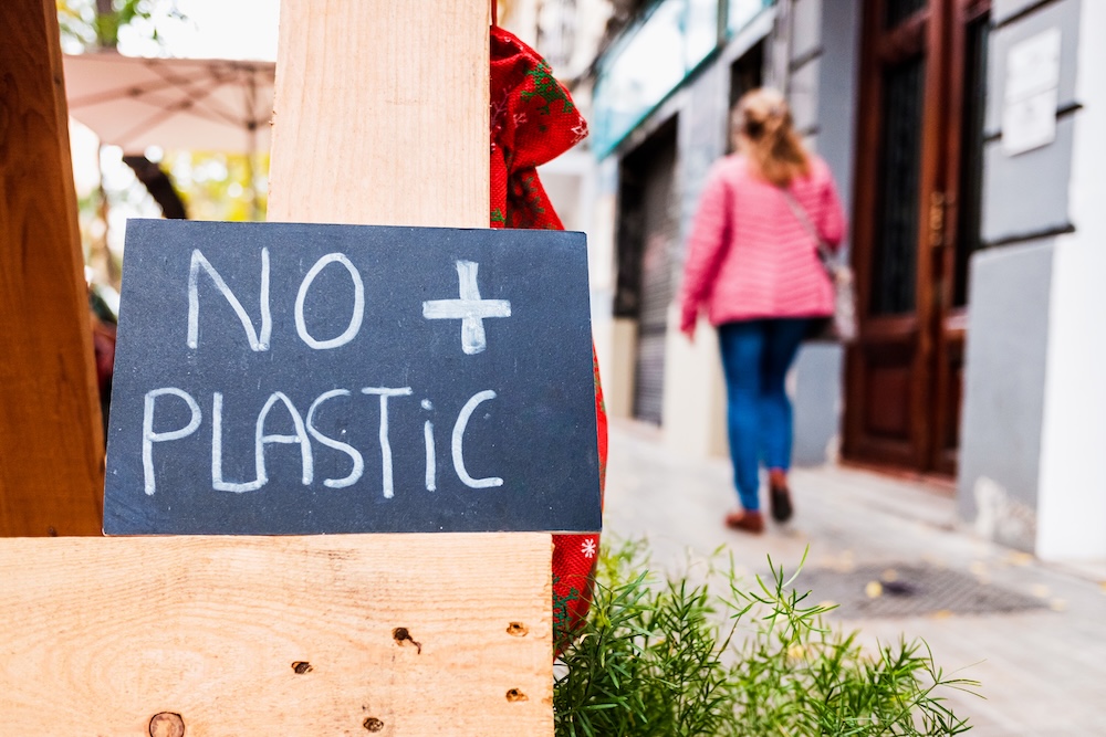 Black sign with white chalk that says no plastic