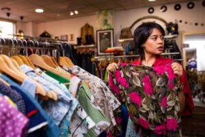Women shopping in a thrift store for floral clothing