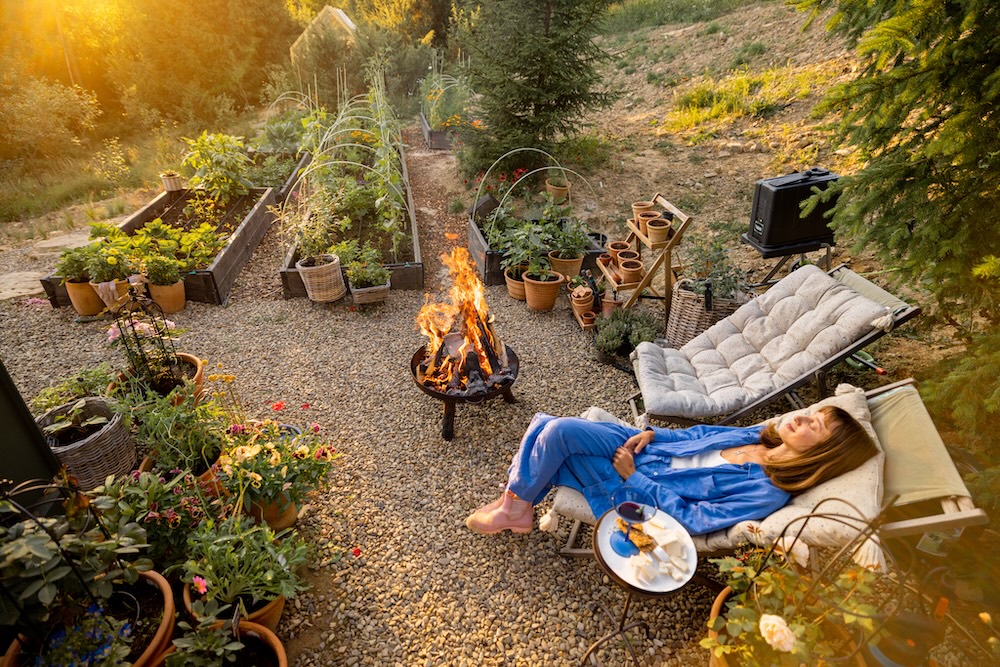 Woman sitting outside enjoying sun going down with plants all around