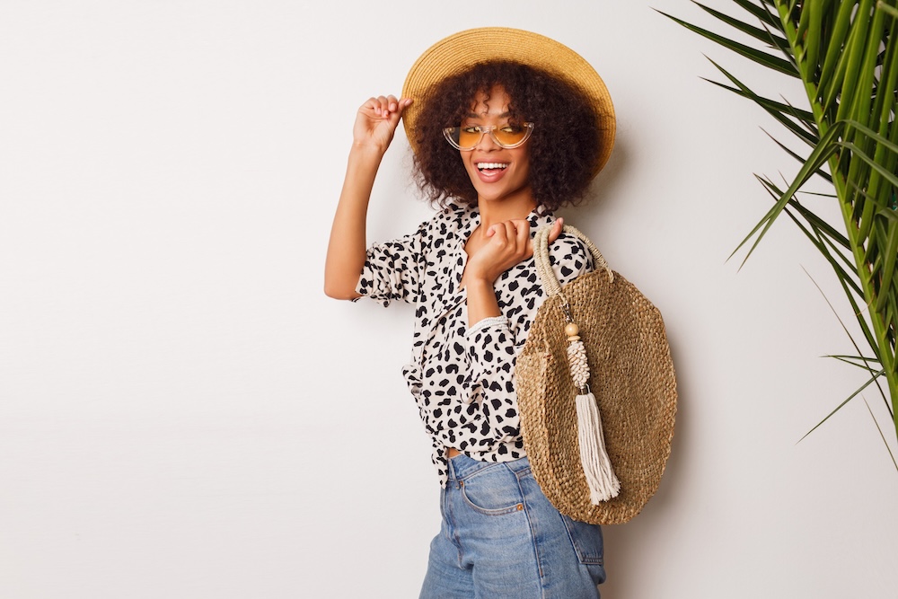 Young woman wearing a natural material hat and bag