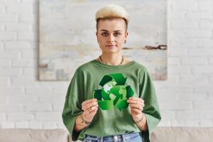 Woman holding a green recycle sign