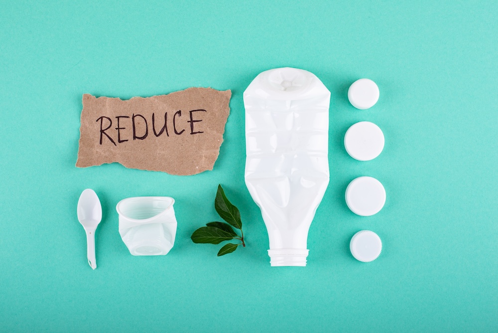 Cardboard with words Reduce with plastic items around