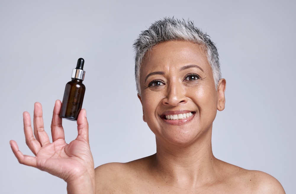 Mature woman holding natural serum in her hands