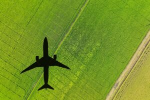 Shadow of an airplane flying over a green field