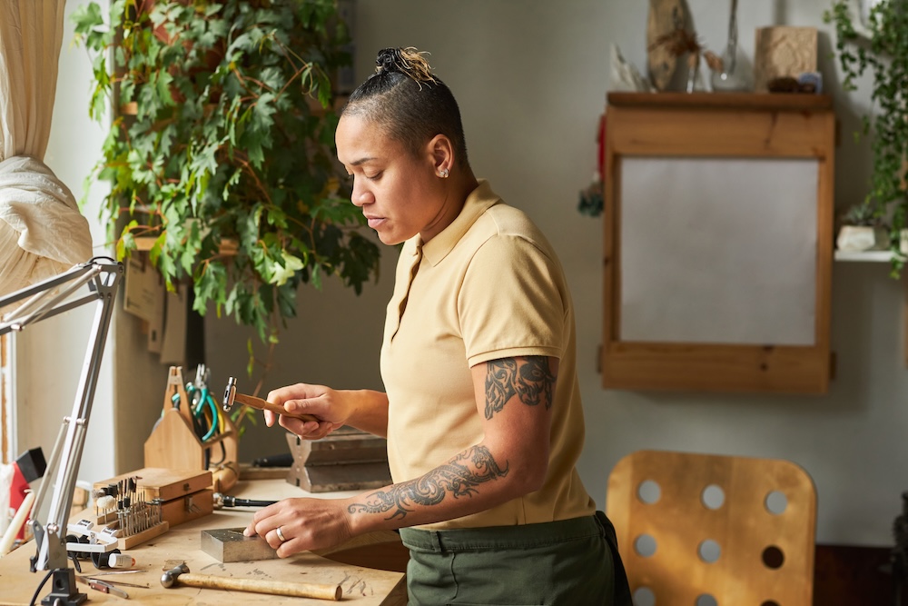 Female artisan creating handmade jewelry in her workshop