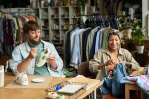 Two people upcycling shoes and a jean jacket