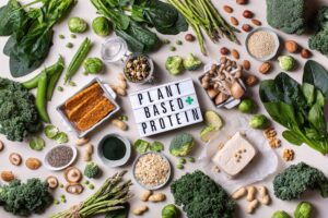 Variety of plant-based proteins spread out with sign says plant-based protein
