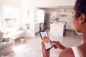 Woman using her smart device to change household settings