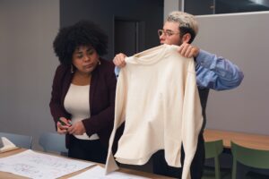 Fashion designers holding a beige sweater