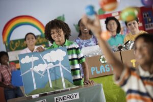 class of children holding artwork of renewable energy concepts