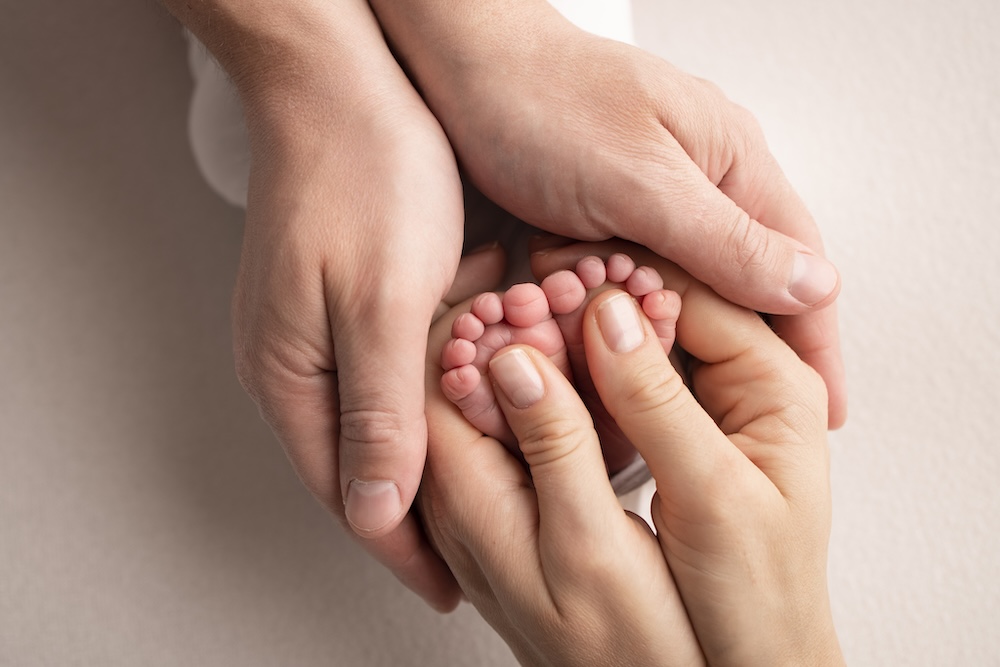 Parents hands holding baby hands