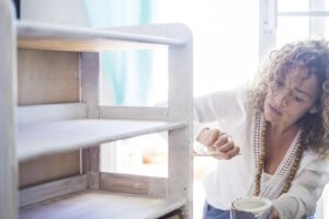 Woman upcycling a piece of shelving
