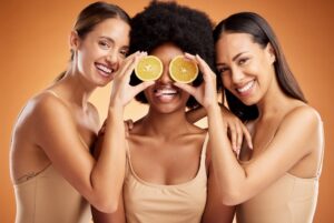 Diverse women with different skin types smiling with a lemon