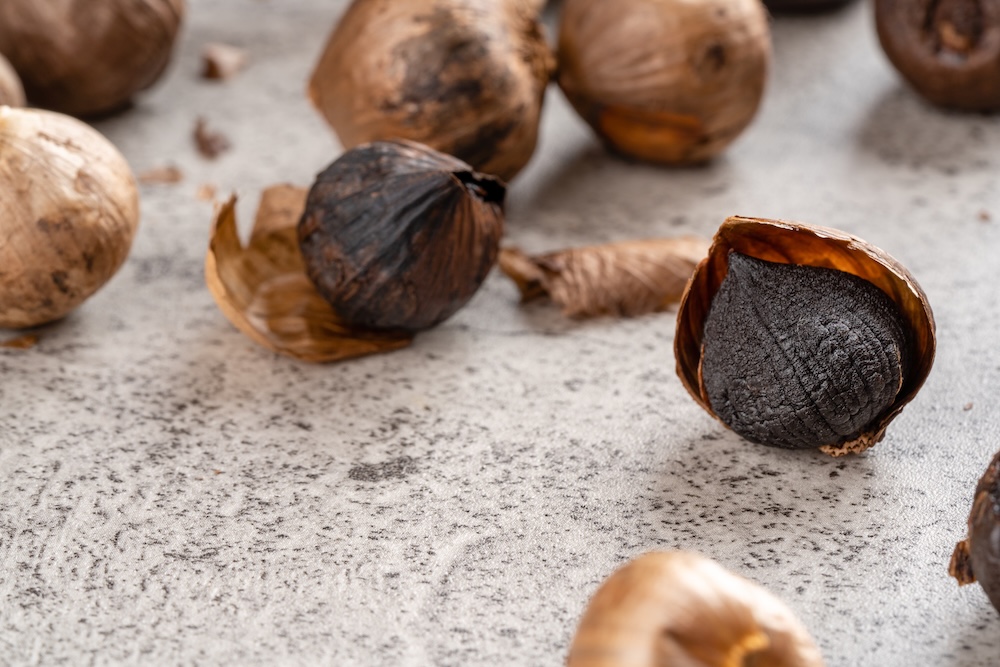 Fermented black garlic cracked open on a table