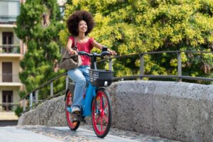 Woman riding an electric bike over a bridge in the city