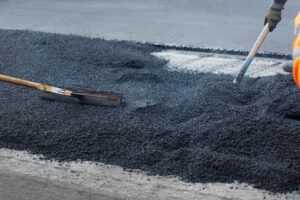 Group of road workers smoothing out asphalt