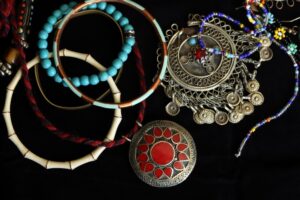 Various pieces of silver and bead jewelry on a black background