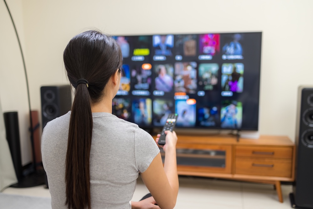 Woman watching a flat screen smart tv in her living room