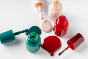Multiple nail polish bottles with one spilled on a table