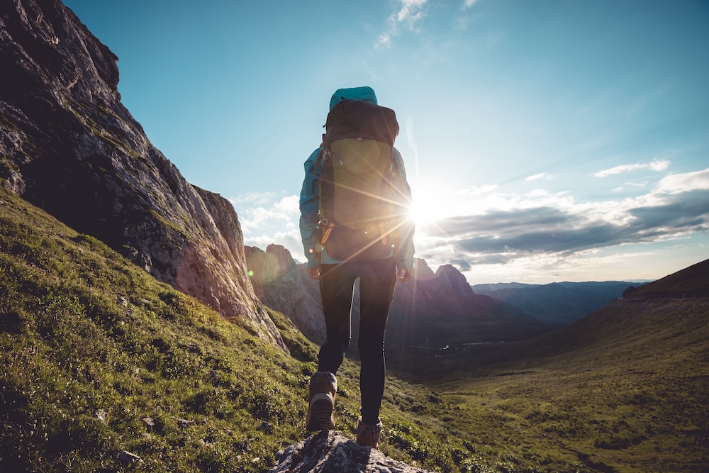 Woman backpacking on a hike at sunset
