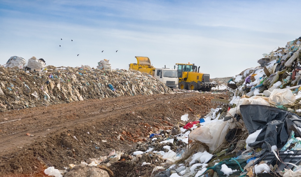 Bulldozer clearing and unloading garbage
