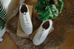 White shoes sitting on a wooden box with plants